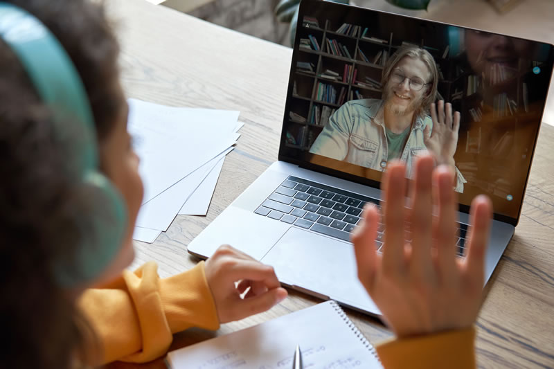 Student waving at online teacher